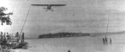 A Piper Cub of the 1st Marine Division’s improvised air force snags a message from a patrol on New Britain's north coast.